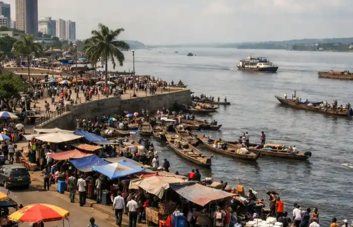 נוף עירוני סואן של קינשאסה לצד נהר קונגו, עם תנועה, סירות וקו רקיע רחב